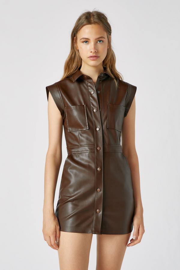 Este vestido corto de estilo camisero de efecto piel en color marrón cuenta con manga corta y cierre mediante botones. Es de Pull & Bear y tiene un precio de 25,99 euros.