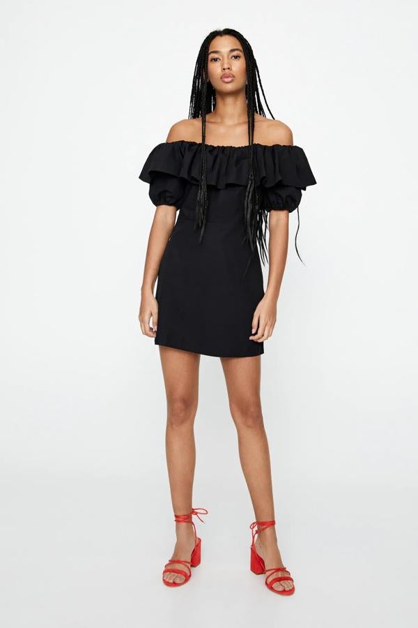 Este vestido midi con escote palabra de honor en color negro cuenta con detalle de volantes. Confeccionado en algodón, ahora tiene un precio de 15,99 euros.