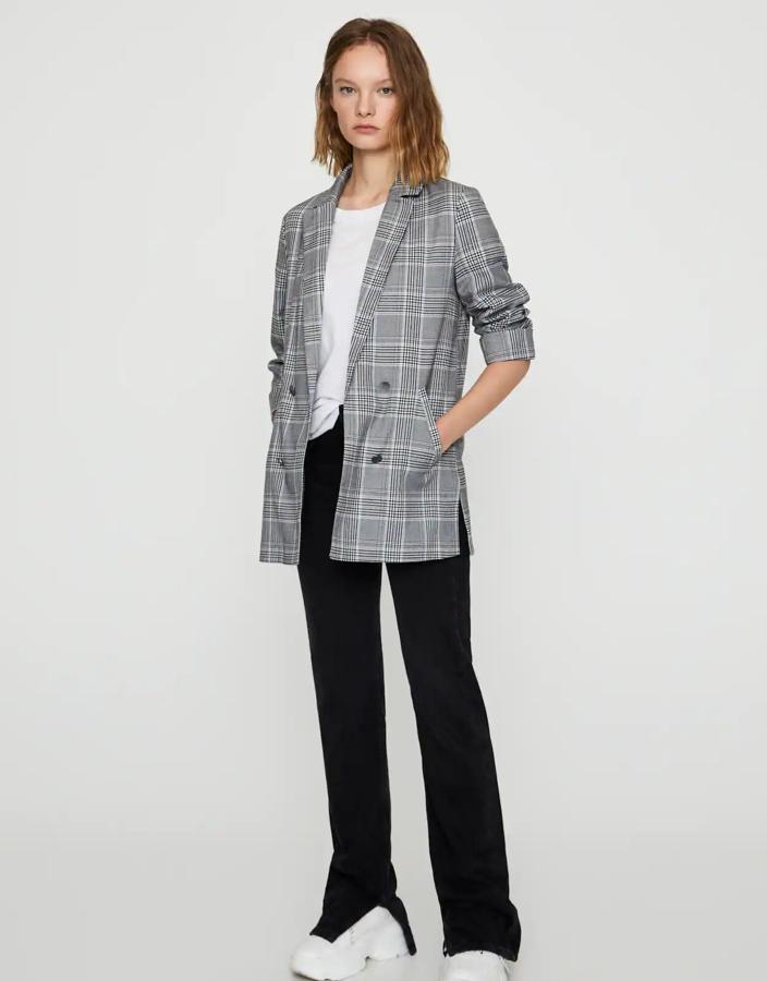 Esta blazer abierta con falsos botones cuenta con estampado de cuadros en blanco y negro y detalle de vuelta en la manga. Es de Pull & Bear y tiene un precio de 25,99 euros.