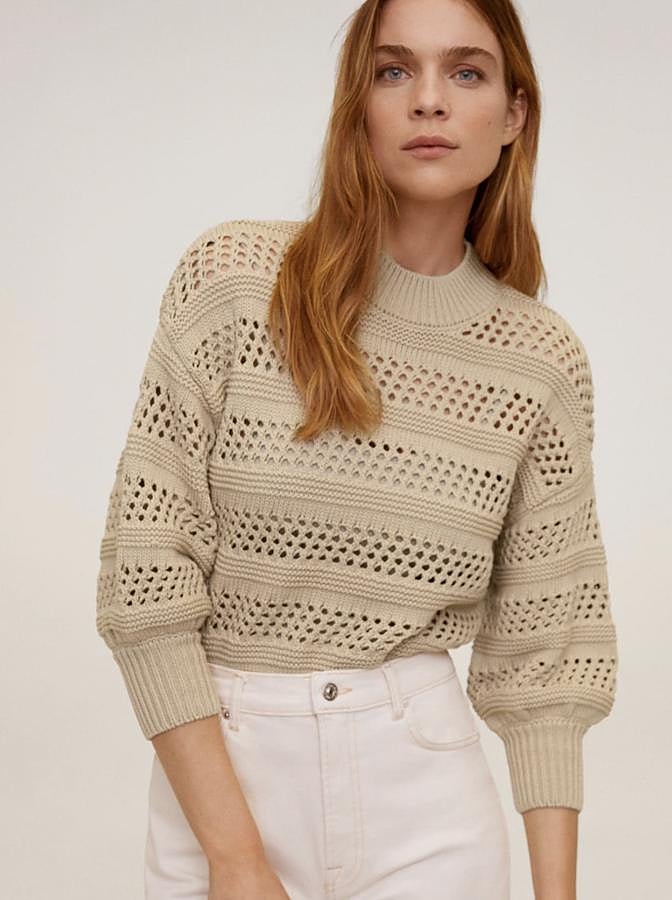 En color beige, este jersey de punto calado y de diseño corto cuenta con cuello perkins y manga tres cuartos. Con terminaciones de canalé, es de Mango y tiene un precio de 29,99 euros.