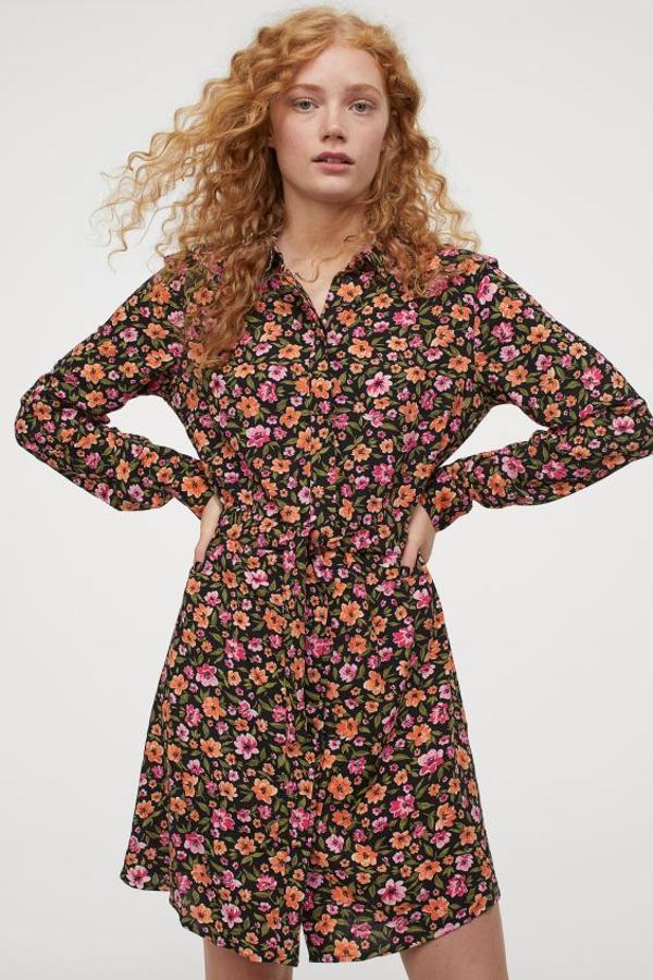 Estampado floral en tonos rosas y naranjas sobre fondo negro para este vestido camisero corto con cinturón a tono extraíble, canesú en la espalda y bajo redondeado. Tiene un precio de 19,99 euros y está disponible entre las tallas 32 y 46.