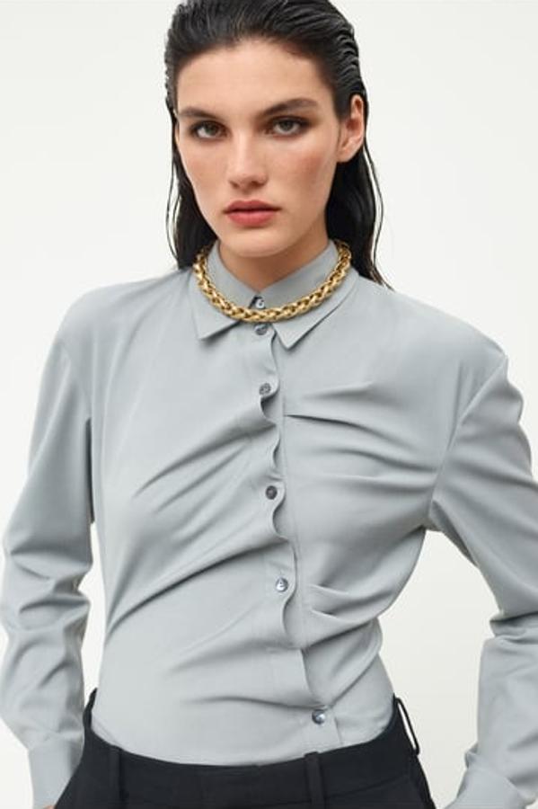 Blusa de manga larga con botonadura en diagonal y frunces, de Zara (49,95 €)