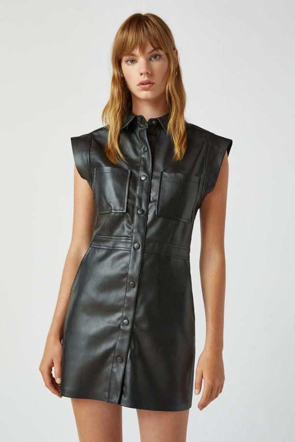 Este vestido camisero de efecto piel dencolor negro cuenta con manga sisa y detalle en la cintura. Tiene cierre mediante botones en la parte delantera y su precio es de 25,99 euros.