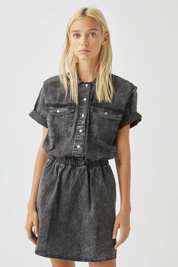 Este vestido de color gris lavado de manga corta cuenta con detalle de goma en la cintura y bolsillos en la parte delantera. Confeccionado en 100% algodón, tiene un precio de 22,99 euros.