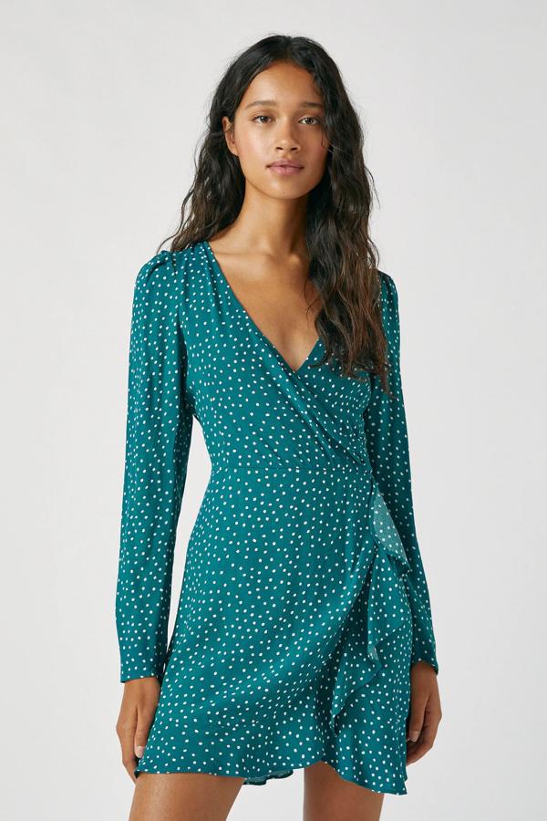 De manga larga y en color verde con pequeños topos blancos, este vestido corto con la parte delantera cruzada tipo pareo tiene un precio de 25,99 euros.