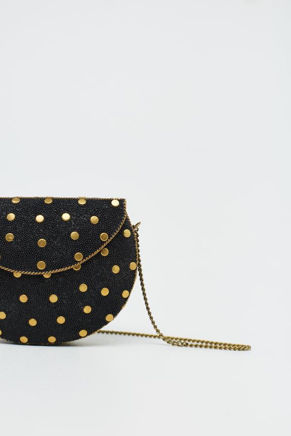 Esta caja rígida con forma ovalada es de Sfera y viene con aplique de tachuelas en color dorado, el mismo tono del asa larga de cadena. Tiene un precio de 16,99 euros.