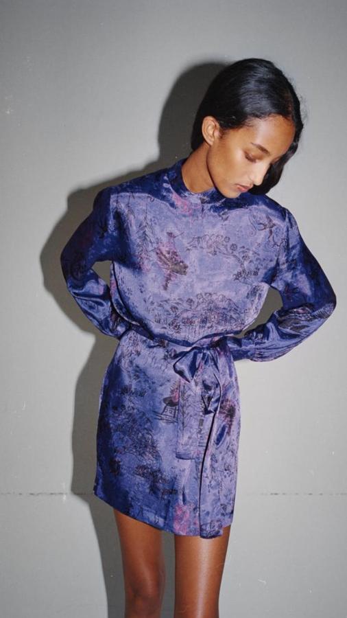 Vestido corto de cuello subido y manga larga abullonada, con cinturón lazada y estampado oriental en color morado (39,95 euros).