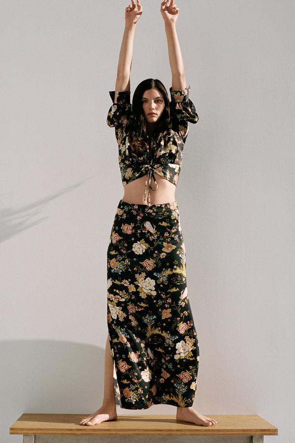 En color negro y con estampado de flores, este total look de Zara está formado por falda (29,95 euros) cut out de tiro alto con aberturas e la cintura y top (29,95 euros) corto con escote de pico y detalle de frunce con cordones ajustables.