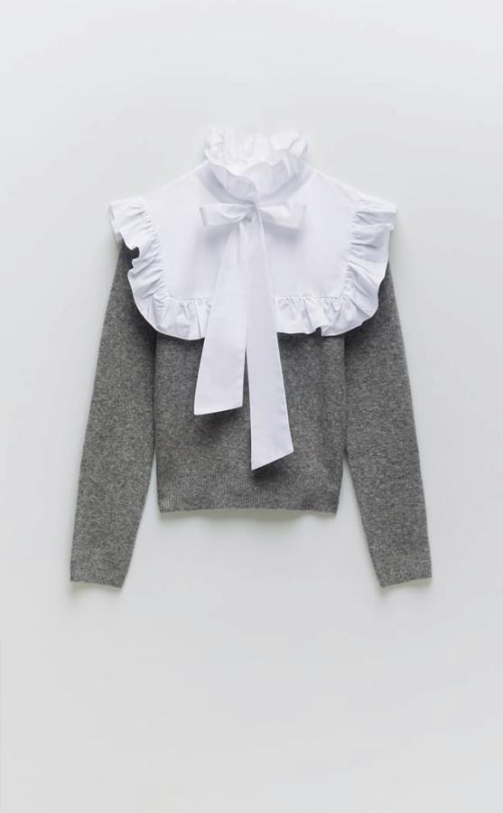 Jersey de lana gris con canesú de popelín en blanco con detalle de lazo, de Zara (25,95 euros).