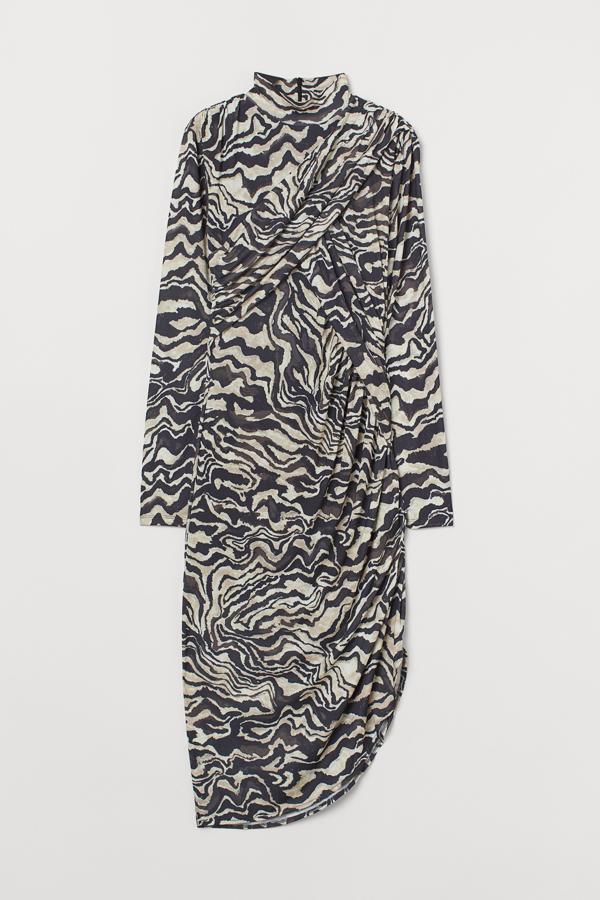 Con estampado de cebra, este vestido midi con cuello elevado y mangas extralargas ceñidas cuenta con falda asimétrica con abertura en un lateral y cremallera oculta en la espalda. Tiene un precio de 39,99 euros.