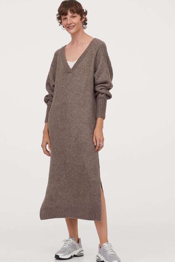 En color grisáceo, este vestido midi en punto suave y escote de pico cuenta con manga larga con franjas de canalé y aberturas laterales. Tiene un precio de 39,99 euros.