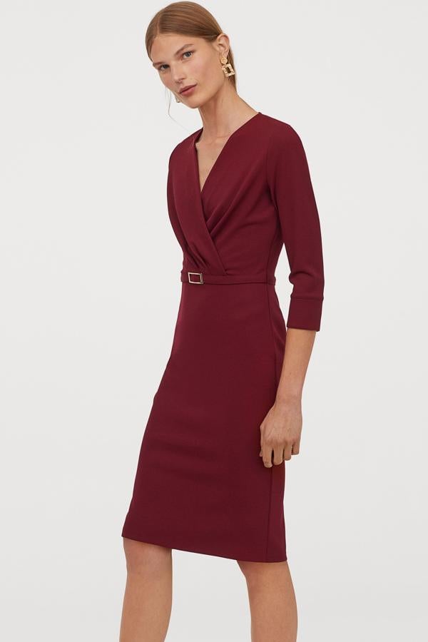 En color rojo oscuro, este vestido en punto grueso con frente cruzado y manga tres cuartos con abertura en los puños tiene un precio de 29,99 euros.