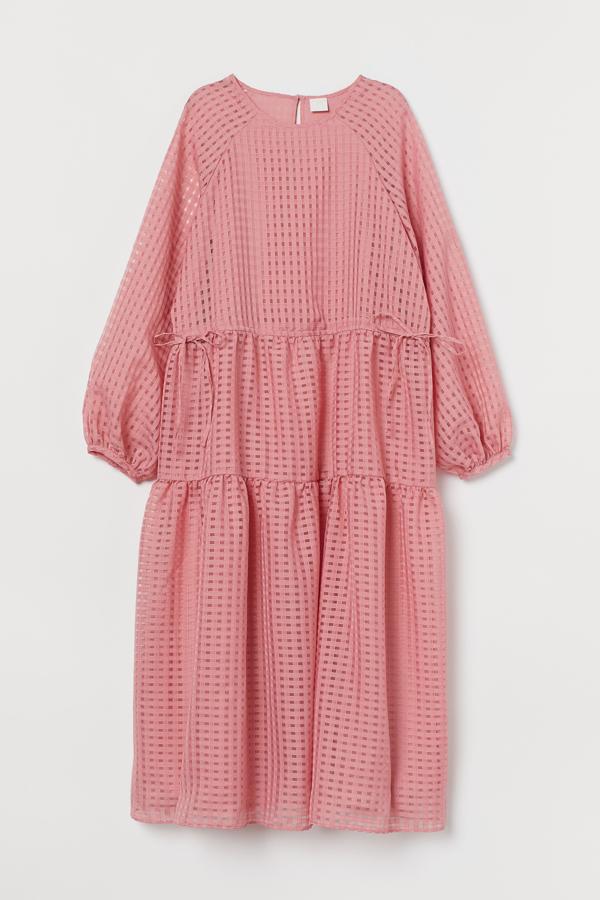 En tejido de Jacquard de color rosa, este vestido midi con cuello redondo y mangas globo largas cuenta con costura en la cintura con cordón y falda escalonada con vuelo. Tiene un precio de 39,99 euros.