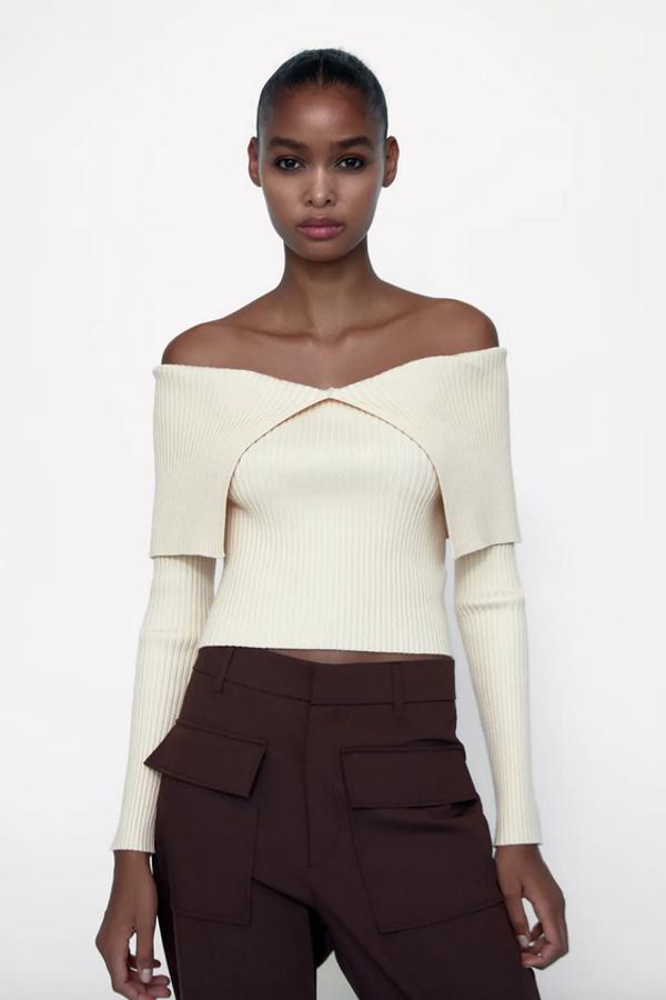 Escote de pico y manga larga con hombros descubiertos para este original top de Zara en color crudo que tiene un precio de 25,95 euros y podemos comprar entre las tallas S y XL.
