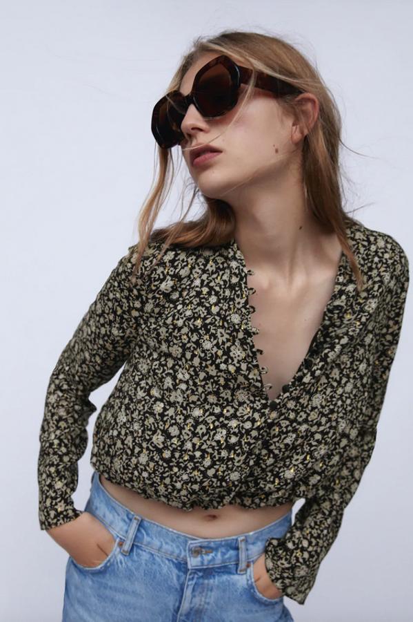 Cuerpo cropped y mangas largas acabadas en abertura para este top de cuello redondo de Zara que tiene cierre frontal de botones forrados y bajo elástico interior. En tonos grises y negros, tiene un precio de 29,95 euros y está disponible entre las tallas XS y XL.