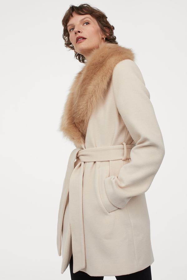 Abrigo corto con cinturón, en blanco roto con cuello de peluche, de la nueva colección de H&M (69,99 euros).