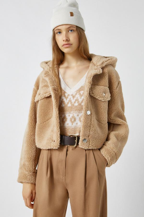 En color tostado o en beige claro, esta cazadora de borreguillo con capucha y bolsillos delanteros tiene un precio de 25,99 euros.