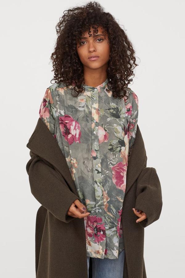 En verde palo con estampado de rosas, esta blusa larga en tejido vaporoso de H&M viene con cuello elevado corto y cierre de botones a tono en el frontal. Con mangas largas con fruncido decorativo en los hombros, canesú con pliegue de caja en la espalda y botón en los puños, viene con bajo redondeado. Podemos encontrarla únicamente entre las tallas S y M por 19,99 euros.