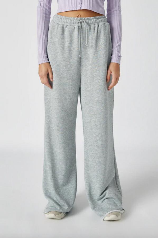 De venta exclusiva en la web de Pull&Bear, este pantalón de pernera ancha de felpa en gris viene con cintura elástica con cordón y con bolsillos delanteros. Cuesta 19,99 euros y está disponible únicamente en las tallas XS, S y L.