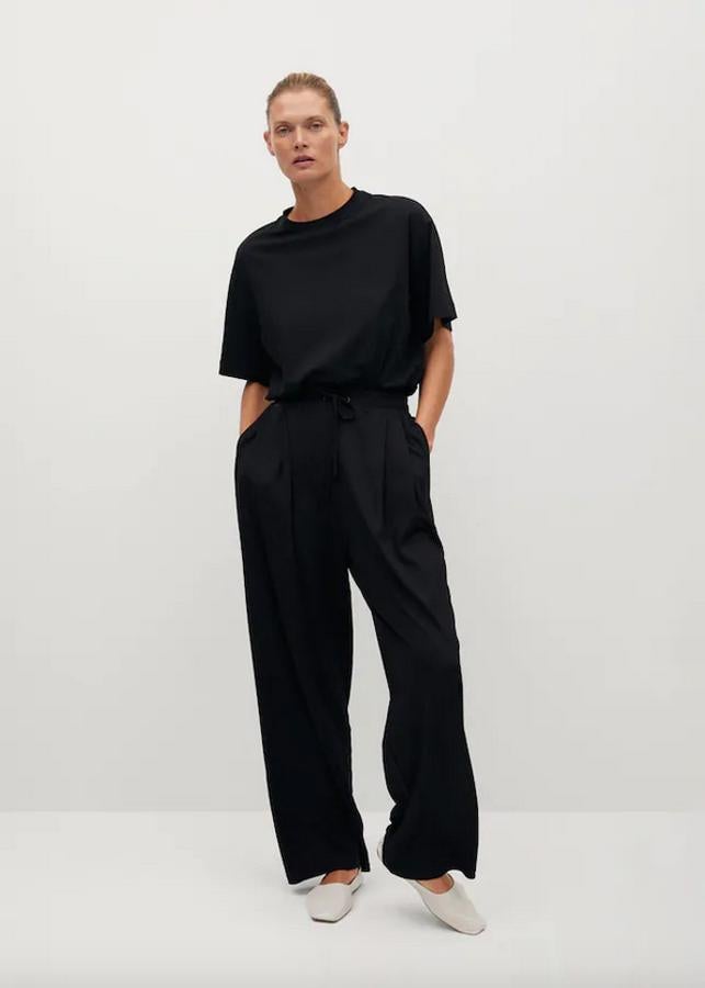 Diseño palazzo y detalle de pinzas para este pantalón negro de Mango con cintura elástica con cordón y perneras rectas anchas. Tiene un precio de 19,99 euros y está disponible entre las tallas XS y XL.