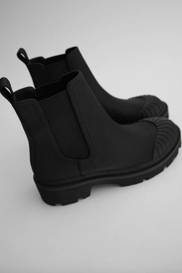 Corte engomado con elásticos en los laterales y puntera con relieve para estos botines de Zara con tirador en la parte trasera y un tacón de 4,2 centímetros. Tienen un precio de 29,95 euros y está disponible entre los números 35 y 42.