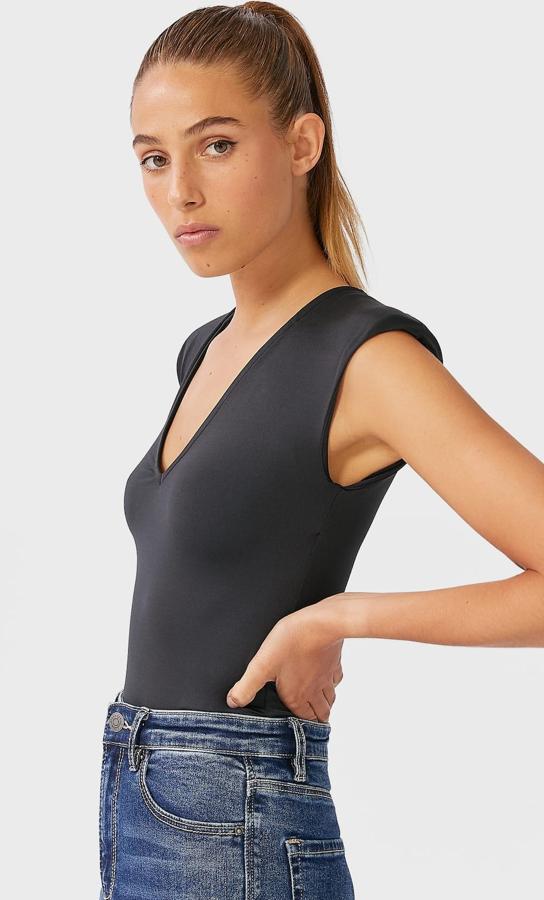 Con escote de pico y manga sisa con detalle de hombreras, este body de color negro cuenta con cierre en el bajo con botones a presión. Tiene un precio de 15,99 euros.