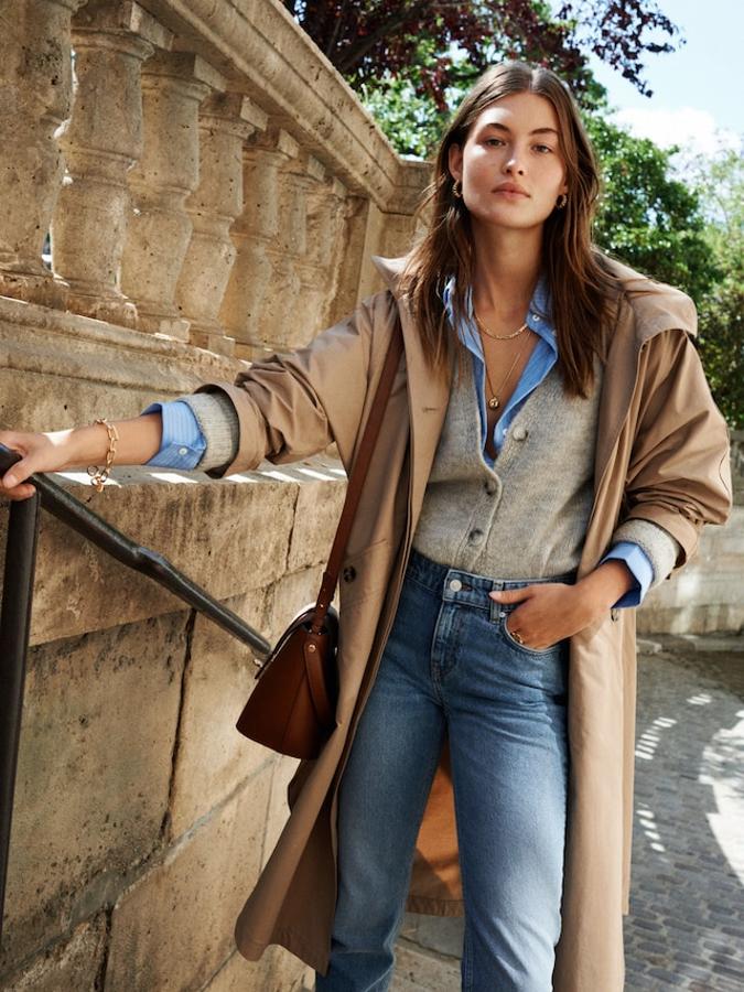 Si tuviéramos que elegir una combinación infallible para nuestros looks de otoño, esa sería la de vaqueros y trench. En esta ocasión, Mango apuesta por una gabardina oversize ( rebajada en las 'mid season' de Mango a 69.99 euros ) y la combina en tonos arena con otra de las prendas clave de esta temporada, el cárdigan de punto (25.99 euros).