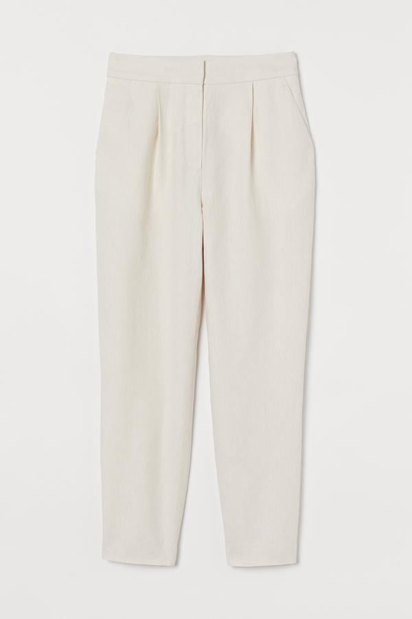 Este pantalón pitillo en mezcla de lino en color beige cuenta con pliegues en la parte delantera y pinzas moldeadoras detrás. Es de H&M y tiene un precio de 29,99 euros.