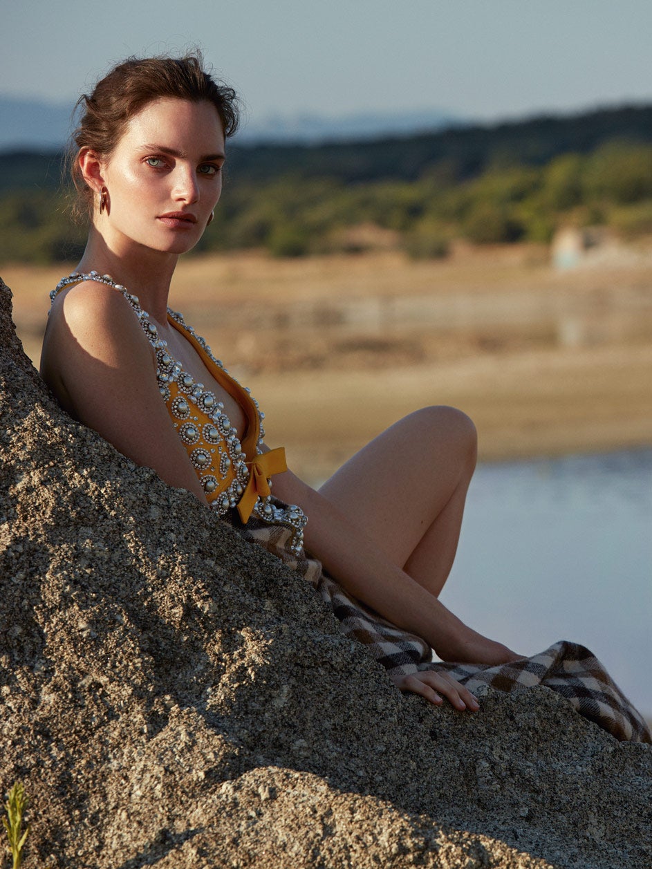 Vestido de lana con perlas y pedrería bordada, de Miu Miu. Los pendientes son de Aristocrazy.