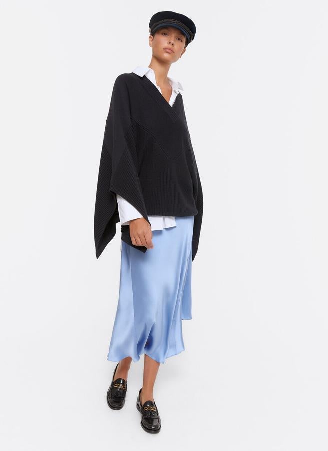 En Uterqüe han apostado por la versión jersey de la capa y la han llevado a esta prenda de cuello de pico cruzado con mangas amplias con abertura lateral. En color negro, tiene un precio de 99 euros y está disponible en la talla M únicamente.