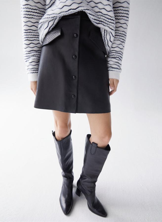 Decorada con pespuntes en la cinturilla y las tapetas del bolsillo, esta falda confeccionada en piel de alta calidad viene con bolsillos cartera con solapas, botones decorativos forrados de piel y cierre de cremallera invisible en la espalda. Podemos encontrarla en las tallas S, M y L por 159 euros.