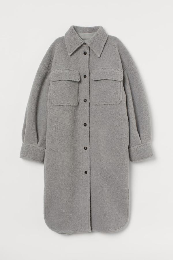 En peluche suave, con cuello clásico, botones delanteros y hombros caídos, esta chaqueta camisera en color gris viene con bolsillos superiores con solapa y bajo redondeado asimétrico. Tiene un precio de 69,99 euros y está disponible entre las tallas XS y XL.