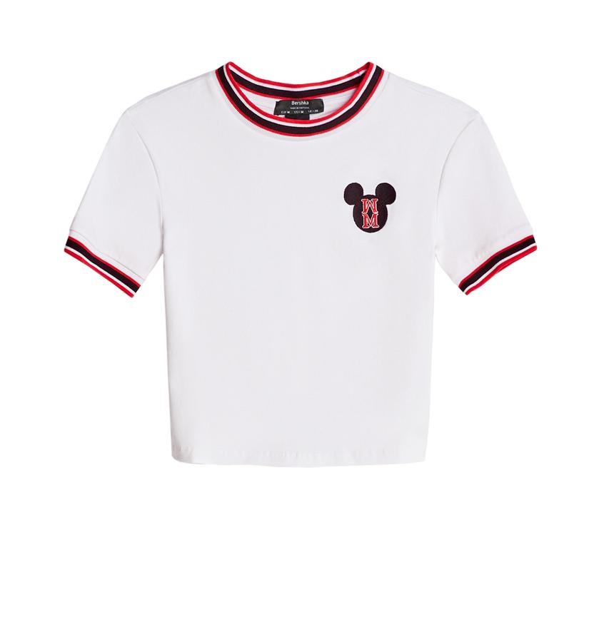 Camiseta blanca de manga corta cropped con remates a contraste y logo en el pecho.