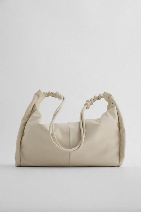 Disponible en crudo o en gris topo, este bolso shopper con tiras laterales para fruncir el cuerpo viene con asa de hombro con detalle de nudos. De 29,95 euros ha pasado a costar 15,99 euros.