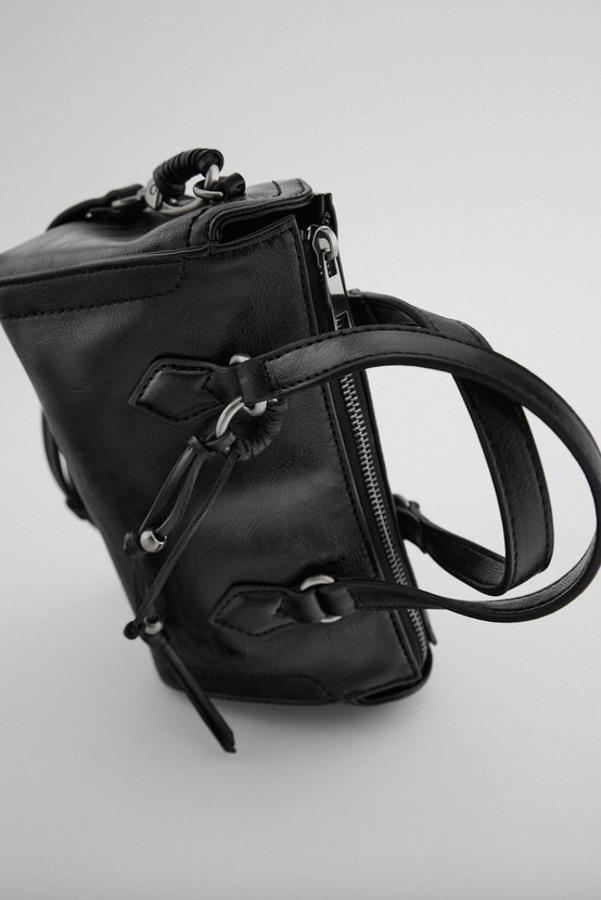 Con asas de mano con detalle de tirador, este bolso en formato bandolera con asa de hombro ajustable y extraíble, todo ello en color negro. Con cierre de cremallera, costaba 19,99 euros y ahora podemos comprarlo por 12,99 euros.