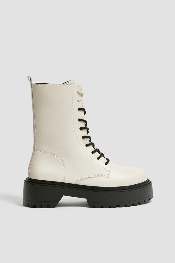 Disponible en crudo o negro, este botín plano de cordones con cremallera en la parte interior tiene una altura de cinco centímetros. Es de Pull & Bear y tiene un precio de 39,99 euros