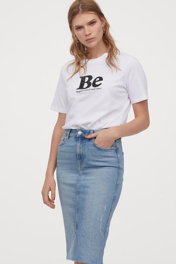 Esta falda tubo denim en color azul también está disponible en negro. Con bajo sin rematar, está confeccionada en algodón parcialmente reciclado y tiene un precio de 29,99 euros.