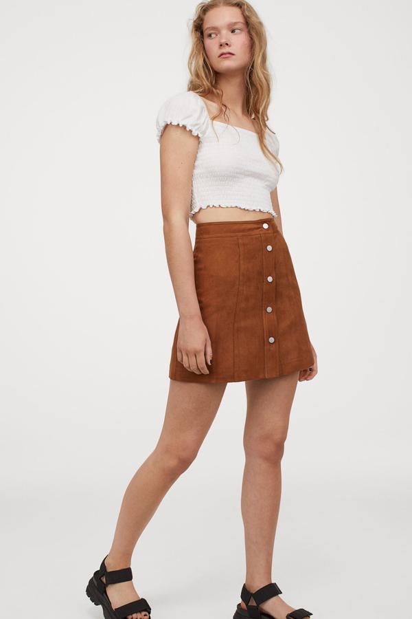 Disponible en varios colores, esta minifalda marrón de corte evasé de talle alto con botones en la parte delantera tiene un precio de 19,99 euros.