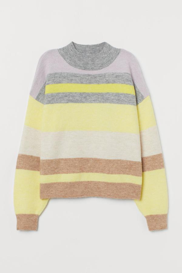 Este jersey con rayas en blanco, gris, amarillo y marrón cuenta con cuello perkins de canalé y remate en puños y bajo. Es de H&M y tiene un precio de 19,99 euros.