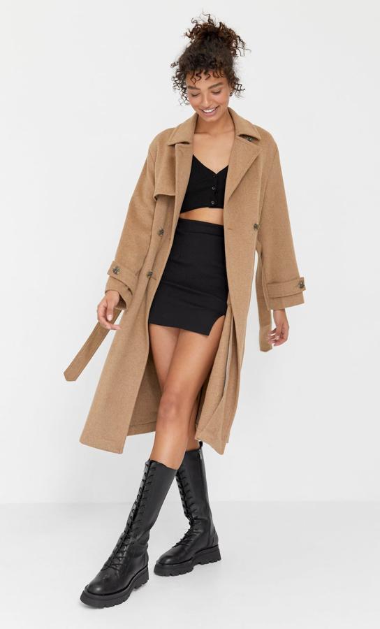 En color beige, este abrigo trench de cuello y solapa con manga larga cuenta con detalle de cinturón y tiene un precio de 59,99 euros.