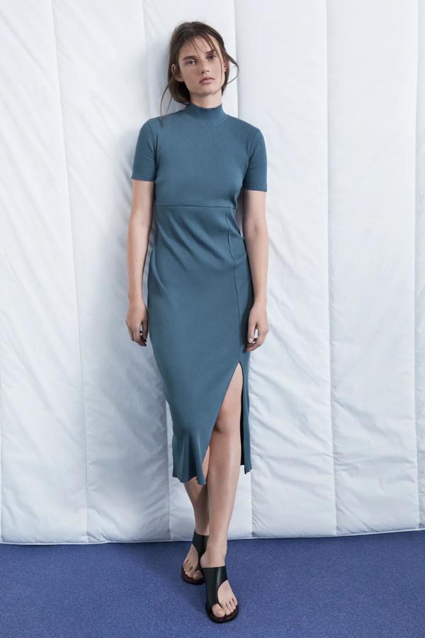 En color azul, este vestido midi de cuello subido y manga corta cuenta con abertura delantera y tiene un precio de 7,99 euros. También está disponible en topo y negro.