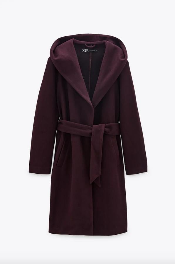 Confeccionado en al menos un 50% de poliéster reciclado, este abrigo con capucha de Zara en color burdeos viene con cuello subido, bolsillos frontales de vivo y cierre de cinturón a tono. Tiene un precio de 39,95 euros y está disponible entre las tallas XS y XL y en los colores negro y beige.