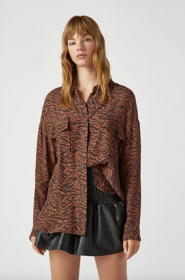 Estampado de leopardo con tonos negros y marrones para esta camisa oversize de Pull&Bear con cuello clásico, bolsillos de plastrón en el pecho con solapa y mangas largas. Confeccionada en viscosa, tiene un precio de 22,99 euros y está disponible entre las tallas XS y L.