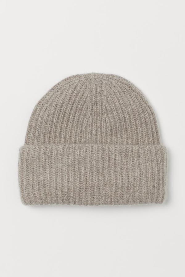 Confeccionado en canalé suave de cachemira cálida con vuelta ancha, este gorro de lana de H&M está disponible en cinco colores, entre ellos dos tonos de gris, el crudo o el negro. Solo se vende en la web de la firma y cuesta 29,99 euros.