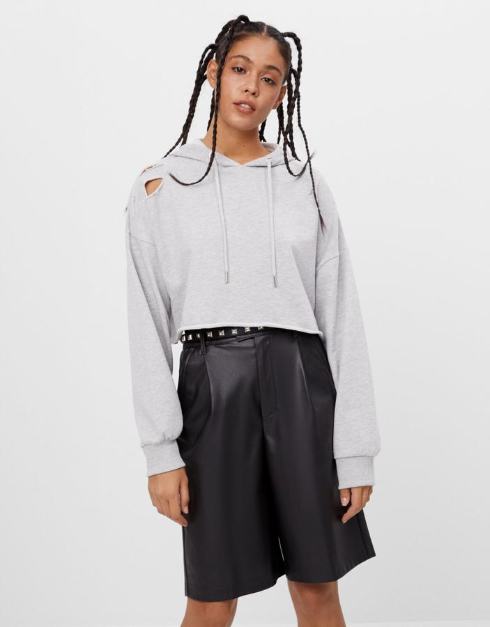 Combinada con una sudadera de algodón con capucha, de Bershka (19,99 €).