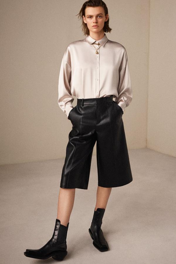 El contraste de texturas es la clave del éxito de este look de Zara: blusa de seda fluida y botines camperos.