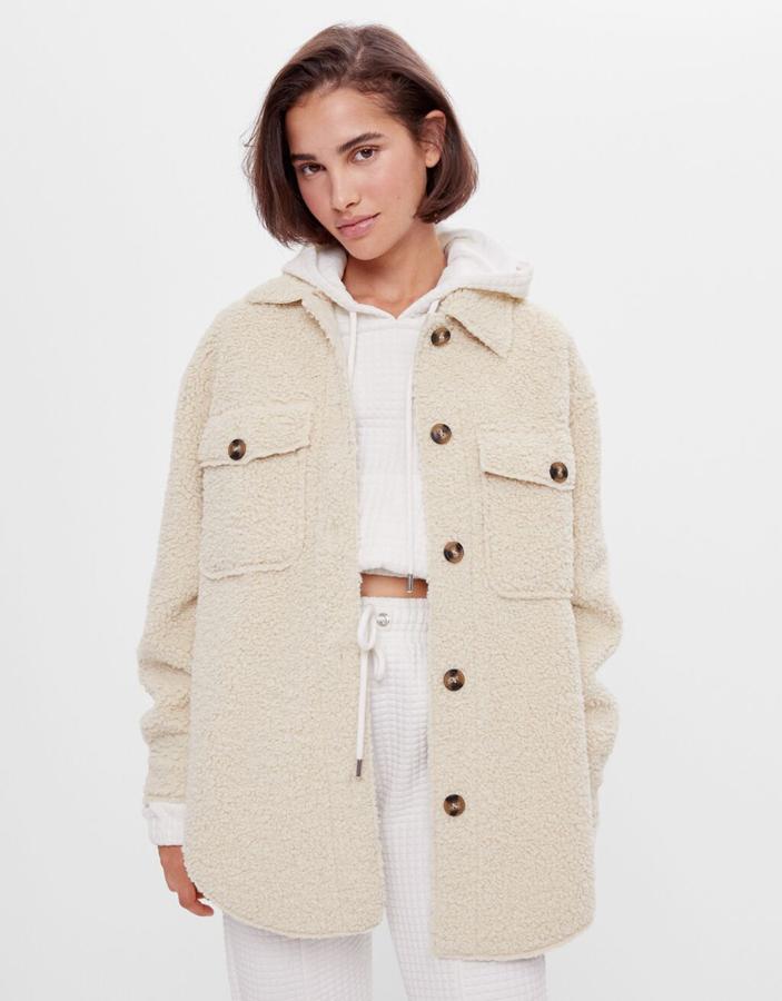 En color crudo, con cierre de botones de carey en el frontal, esta sobrecamisa reversible de Bershka permite escoger si el borreguito va por dentro o por fuera, aunque ambas mantiene el tono. Tiene un precio de 45,99 euros y está disponible entre las tallas XS y L.