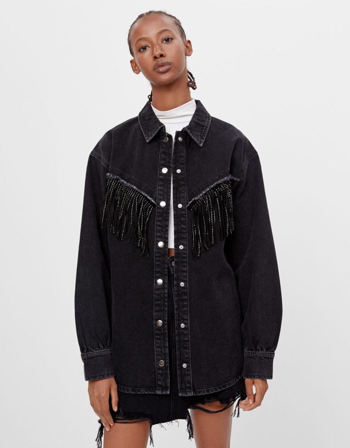 Confeccionada con un 50% de algodón orgánico, esta sobrecamisa de Pull&Bear en tejido denim con cierre frontal de botones a presión y cuello clásico viene con adorno de flecos en pecho y en la espalda. Está rebajada en la web de la firma y de 39,99 euros ha pasado a costar 23,99 euros, y podemos encontrarla en las tallas XS-S y M-L.
