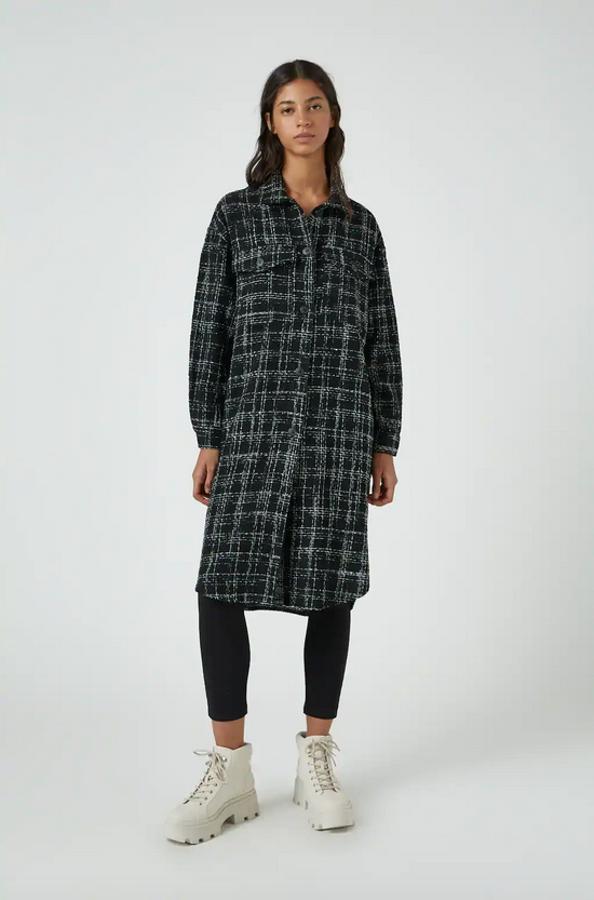 De venta exclusiva en la web de Pull&Bear, esta sobrecamisa larga de cuadros de fondo negro y estampado en blanco viene con cuello clásico y cierre frontal de botones. Confeccionada en mezcla de algodón, podemos encontrarla en las tallas S y M por 39,99 euros.