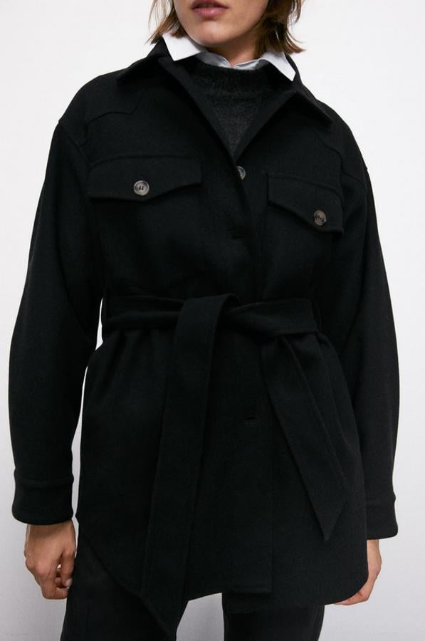 Con cinturón a tono, bolsillos delanteros de plastrón con solapa y bolsillos laterales ocultos en costura, esta sobrecamisa negra de Zara con cierre de botones combinados a contraste tiene un precio de 39,95 euros y está disponible entre las tallas S y XXL.